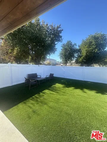 a view of a backyard with plants and a bench