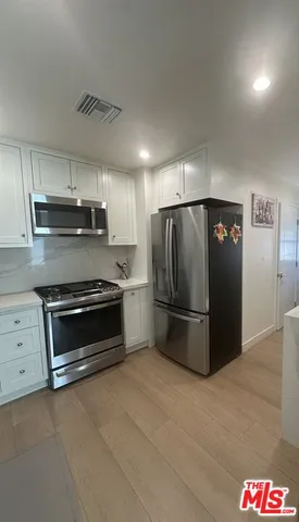 a kitchen with a refrigerator and a stove top oven