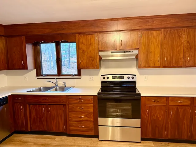 a kitchen with wooden cabinets and a stove top oven