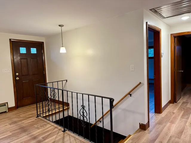 a view of hallway with stairs and wooden floor