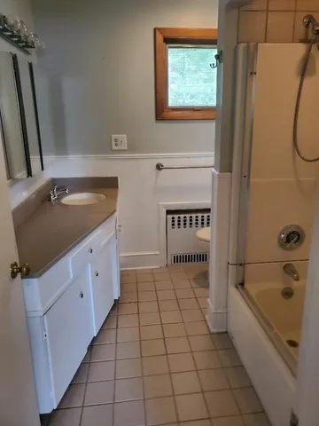 a bathroom with a sink a toilet a mirror and shower