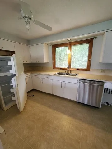 a kitchen with granite countertop a sink a counter top space cabinets and stainless steel appliances