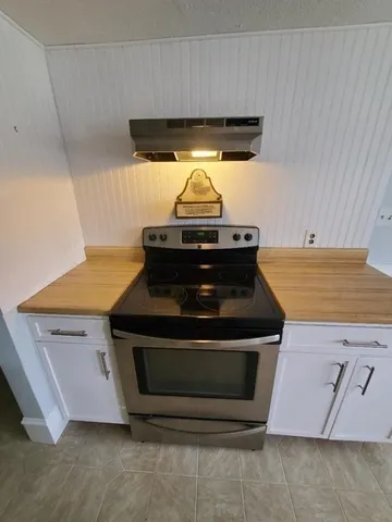 a stove top oven sitting inside of a kitchen