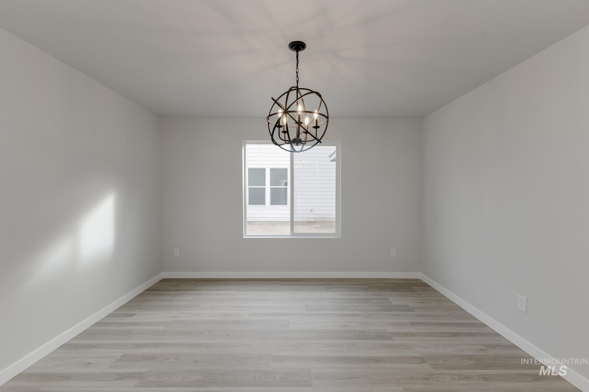 13683 Higley Court Caldwell, ID 83607 - Photo 16 of 31 Spare room with light wood finished floors and a chandelier