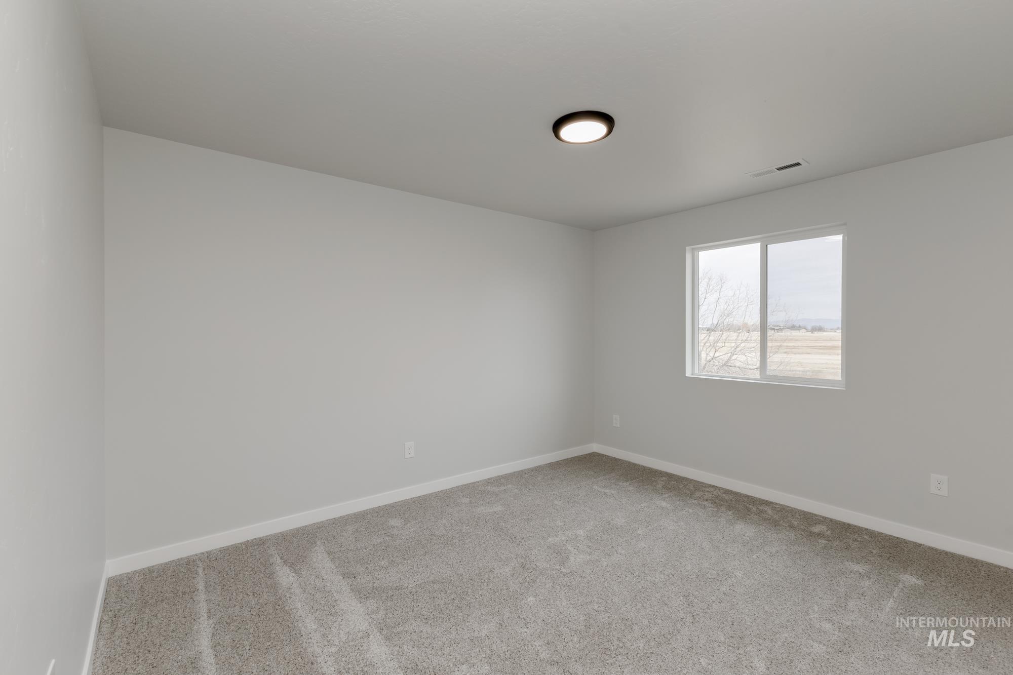 13683 Higley Court Caldwell, ID 83607 - Photo 22 of 31 Empty room featuring light carpet and baseboards