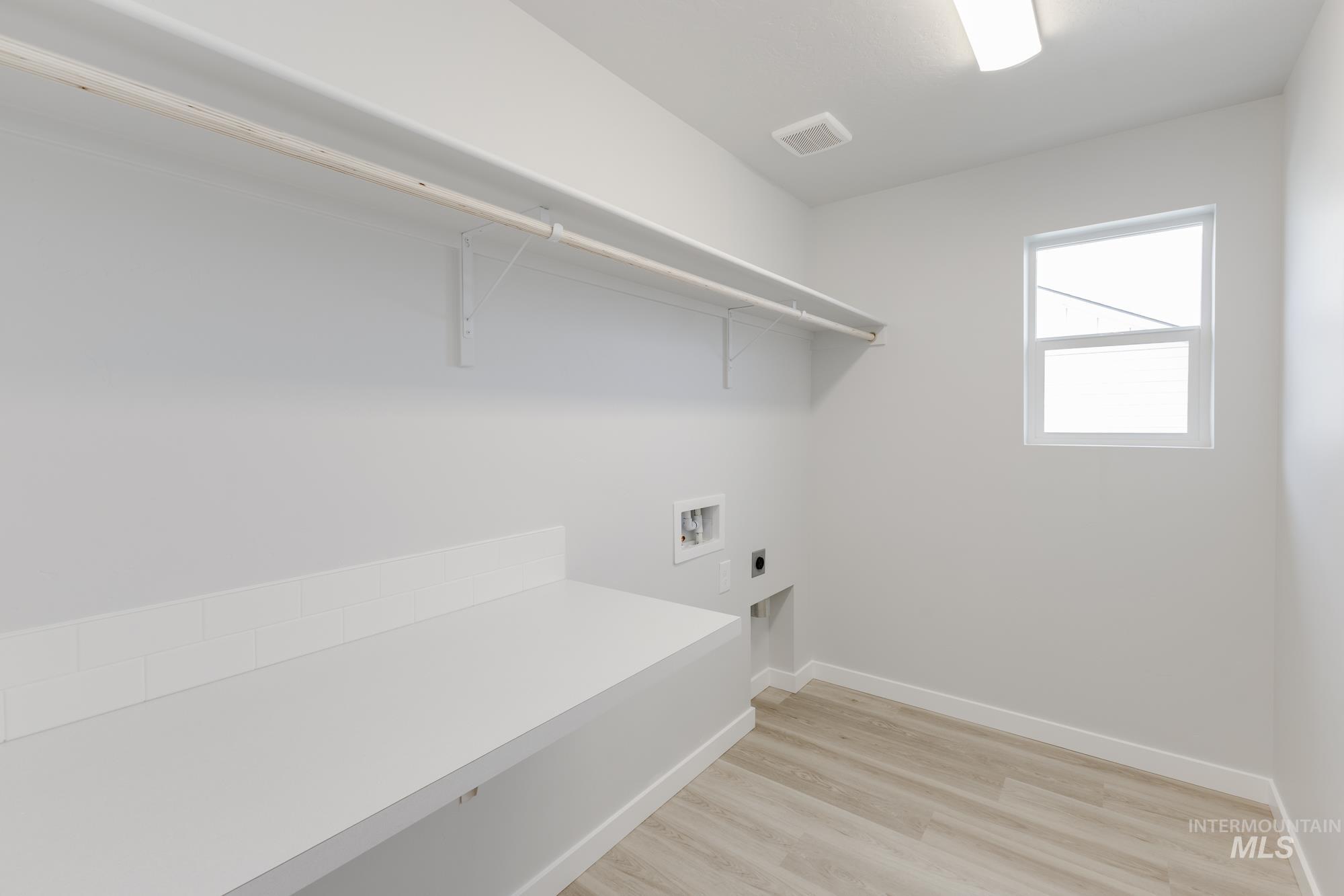 13683 Higley Court Caldwell, ID 83607 - Photo 25 of 31 Laundry area featuring electric dryer hookup, light wood finished floors, and washer hookup