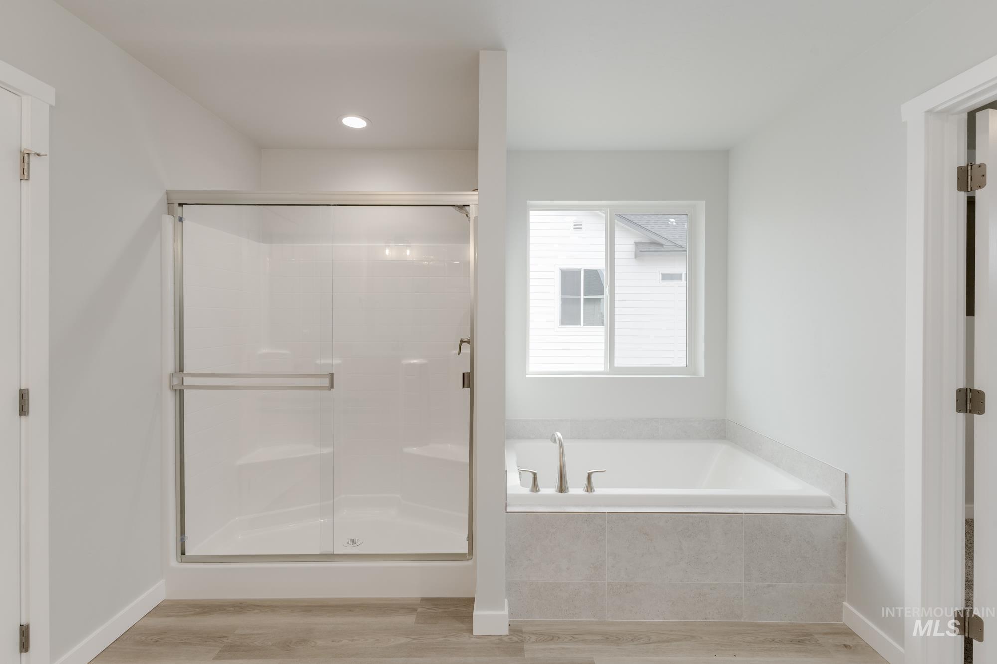 13683 Higley Court Caldwell, ID 83607 - Photo 29 of 31 Bathroom with a garden tub, light wood finished floors, and a shower stall