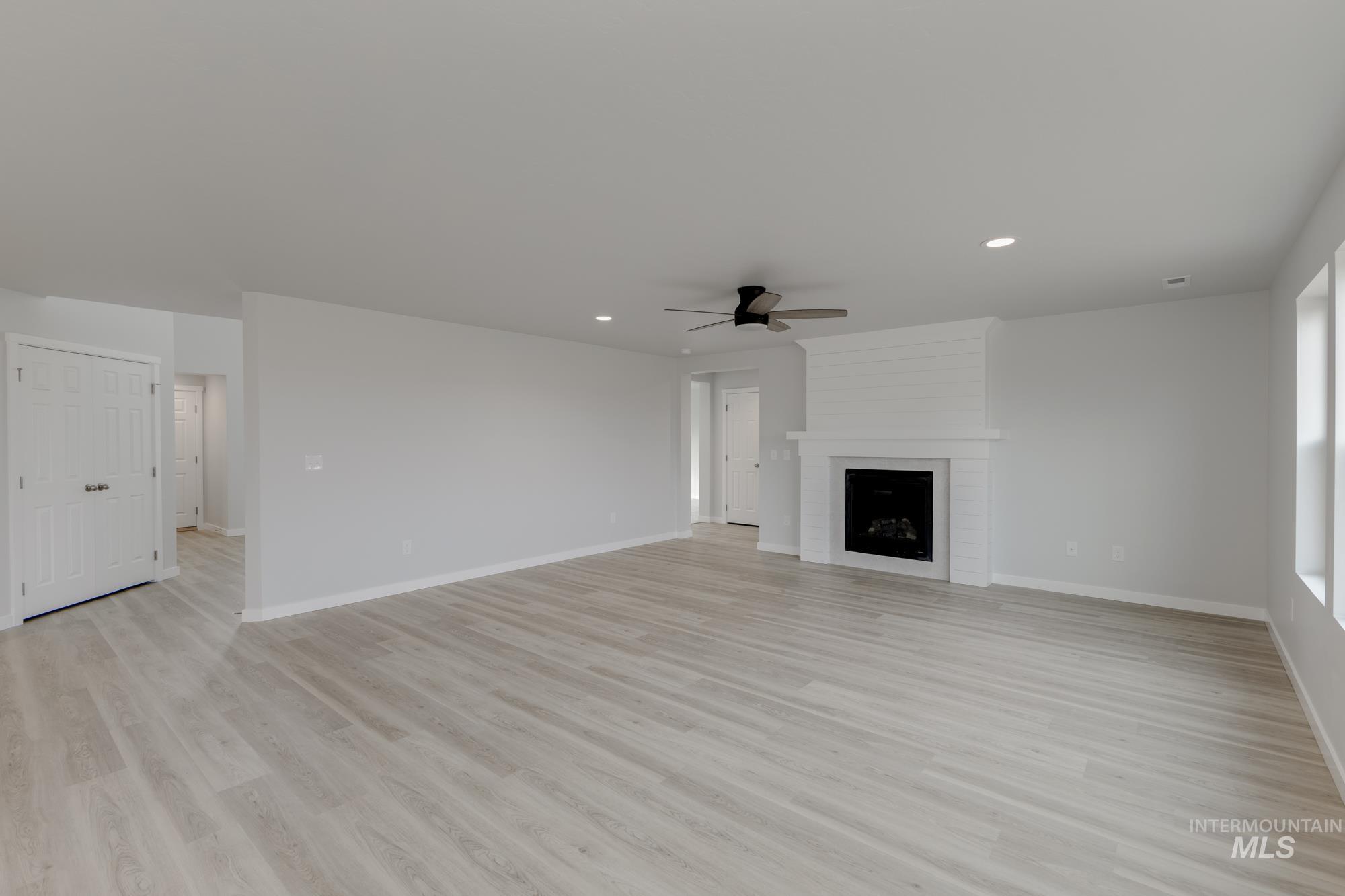 13683 Higley Court Caldwell, ID 83607 - Photo 9 of 31 Unfurnished living room featuring light wood-style flooring, a fireplace, recessed lighting, and a ceiling fan