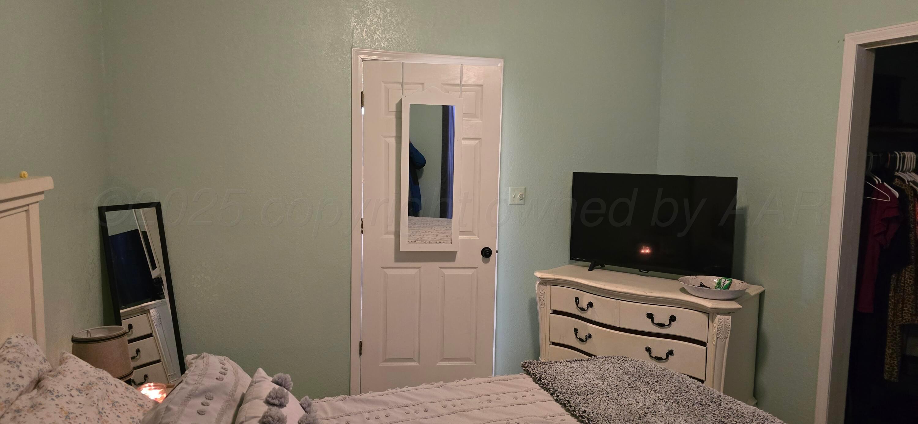 2115 Hemlock Street Borger, TX 79007 - Photo 17 of 43 a bedroom with a bed and flat tv screen on a dresser