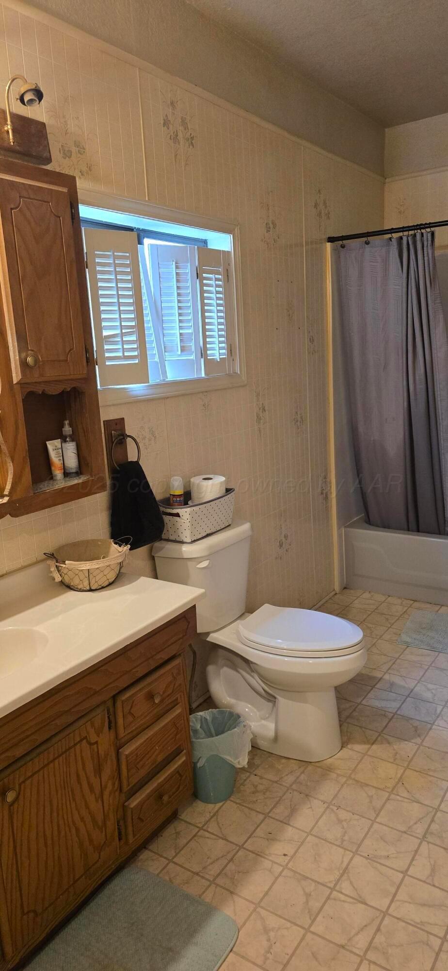 2115 Hemlock Street Borger, TX 79007 - Photo 19 of 43 a bathroom with a toilet a sink and a mirror