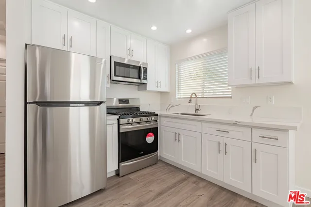 a kitchen with stainless steel appliances granite countertop a refrigerator sink and stove