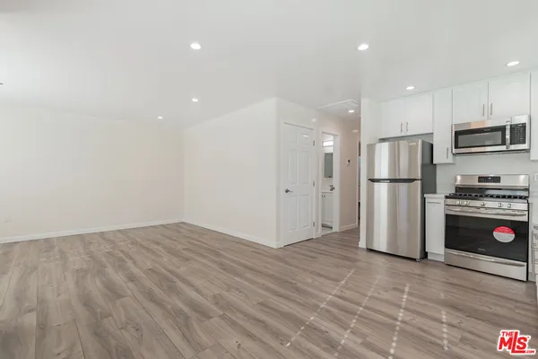 a kitchen with stainless steel appliances a refrigerator and a stove top oven