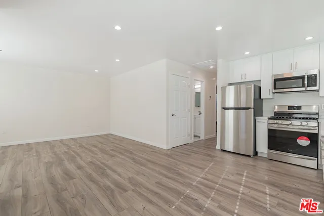 a kitchen with stainless steel appliances a refrigerator and a stove top oven