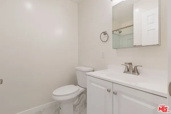 a bathroom with a sink a toilet and mirror