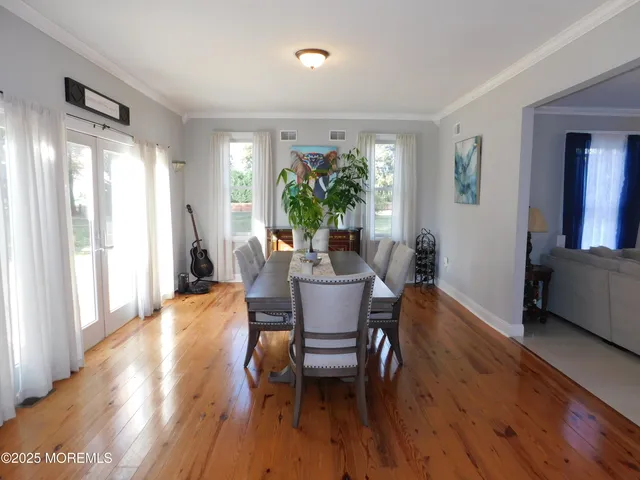 a dining room with furniture window and wooden floor