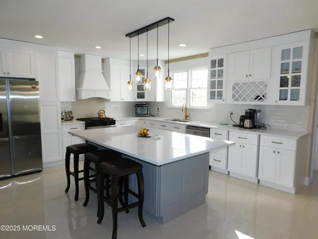 a kitchen with a sink a stove a refrigerator and cabinets