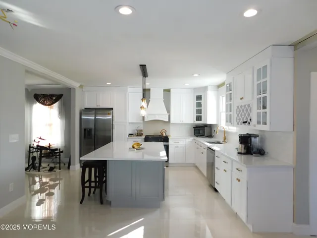a kitchen with white cabinets and stainless steel appliances