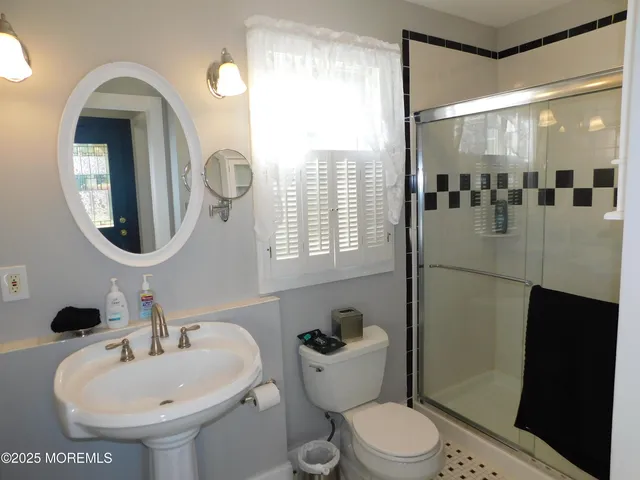 a bathroom with a sink a toilet and a mirror