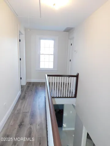 a view of a livingroom with wooden floor and staircase