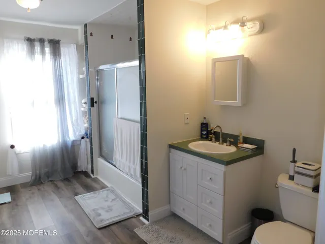 a bathroom with a granite countertop sink toilet and shower
