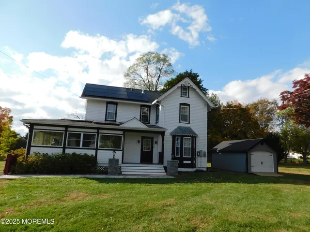 a front view of a house with a garden and trees