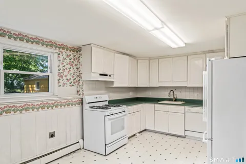 a kitchen with stainless steel appliances a refrigerator sink and white cabinets
