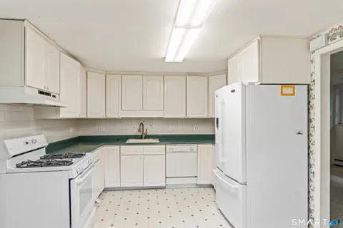 a kitchen with granite countertop white cabinets and a stove