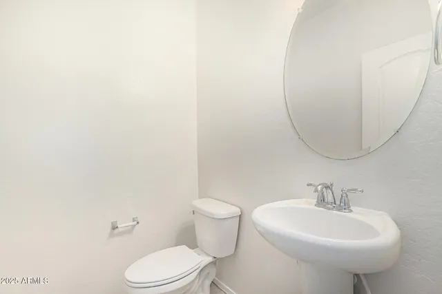 a white toilet sitting next to a white sink