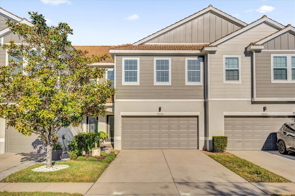 a view of a house with a yard and potted plants