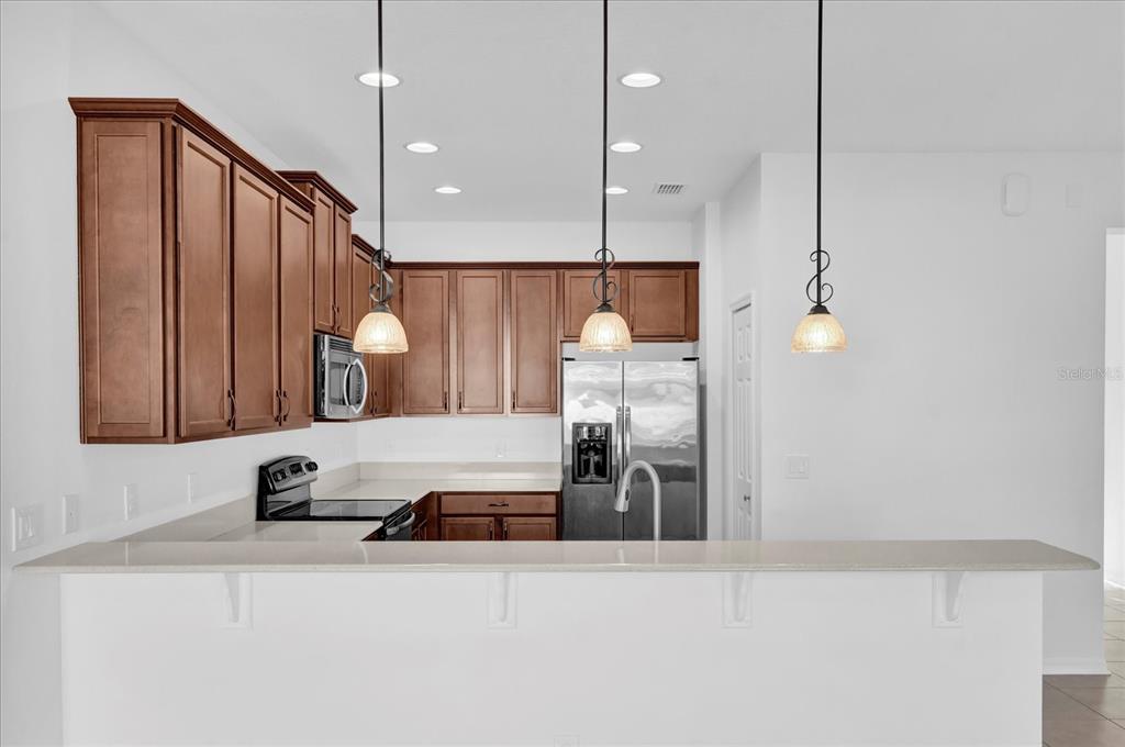 9084 Shepton Street Orlando, FL 32825 - Photo 7 of 26 a kitchen with a refrigerator a sink and wooden floor