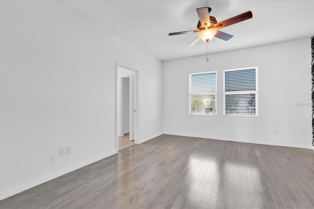 9084 Shepton Street Orlando, FL 32825 - Photo 9 of 26 an empty room with wooden floor and a window