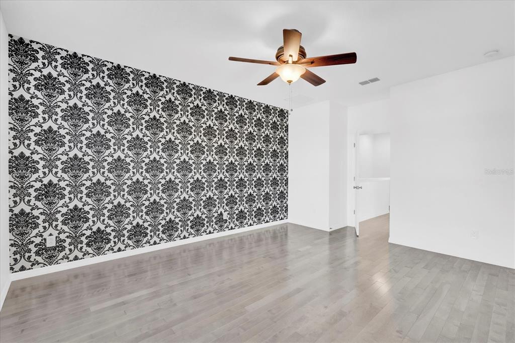 9084 Shepton Street Orlando, FL 32825 - Photo 10 of 26 an empty room with wooden floor fan and windows