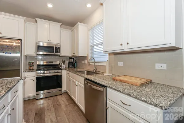 a kitchen with granite countertop a sink and steel appliances