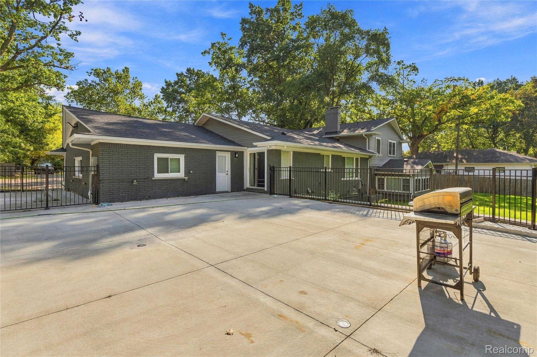 15879 Millar Road Clinton Township, MI 48036 - Photo 38 of 65 Expansive concrete patio with a black metal fence