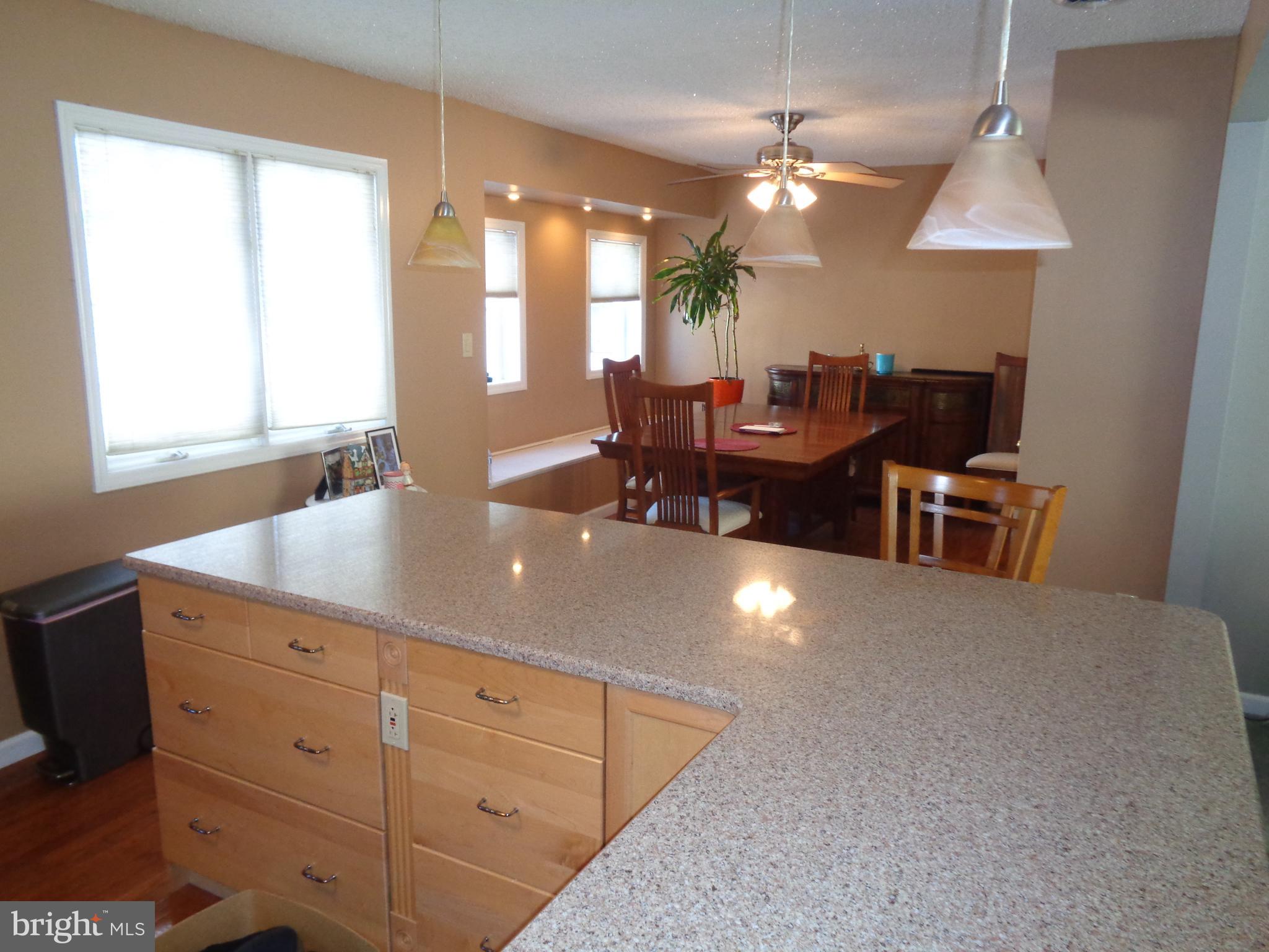 2380 Klockner Road Hamilton, NJ 08690 - Photo 5 of 21 a open kitchen with granite countertop a stove a sink a dining table and chairs with wooden floor