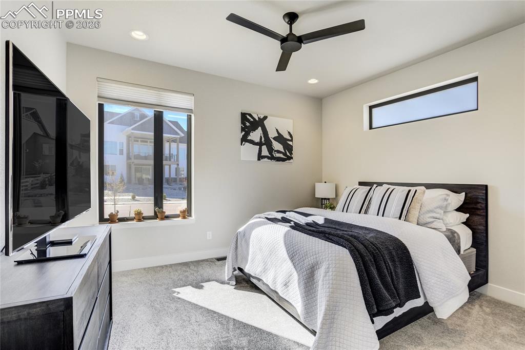 12284 Monarchos Lane Colorado Springs, CO 80921 - Photo 22 of 50 a spacious bedroom with a large bed and a chandelier