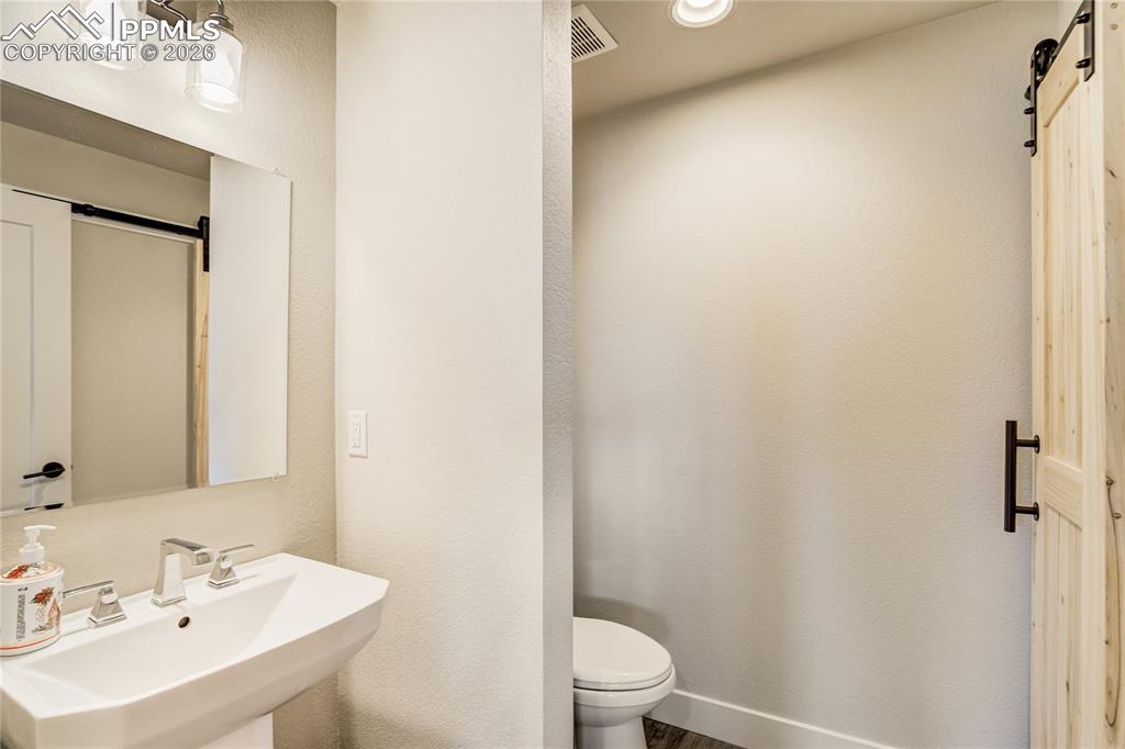 12284 Monarchos Lane Colorado Springs, CO 80921 - Photo 33 of 50 a bathroom with a sink a toilet and a mirror