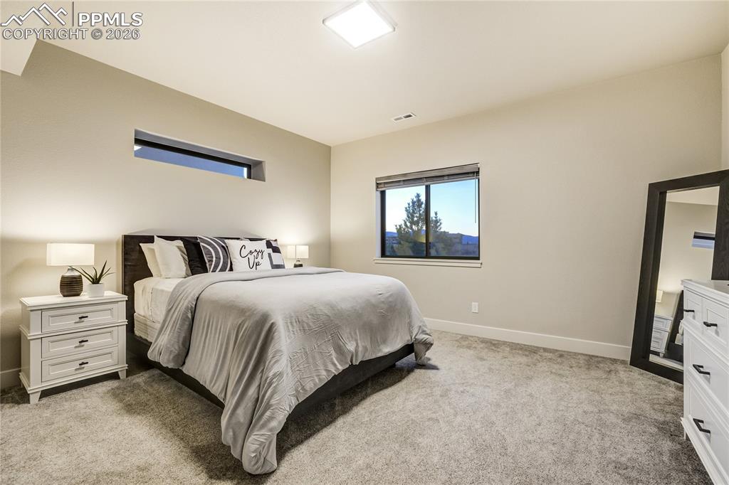 12284 Monarchos Lane Colorado Springs, CO 80921 - Photo 34 of 50 a spacious bedroom with a bed and a window