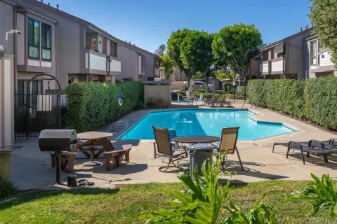 a view of a patio with table and chairs potted plants with wooden floor and fence