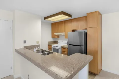 a kitchen with stainless steel appliances granite countertop a sink a refrigerator and a stove
