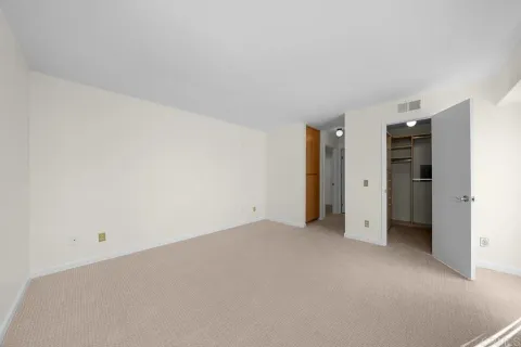 an empty room with closet and a window