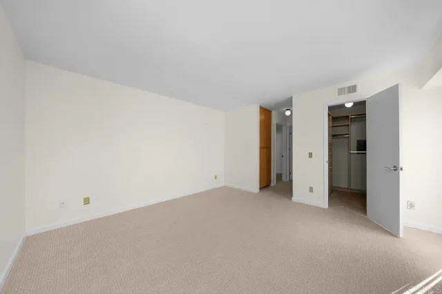 an empty room with closet and a window