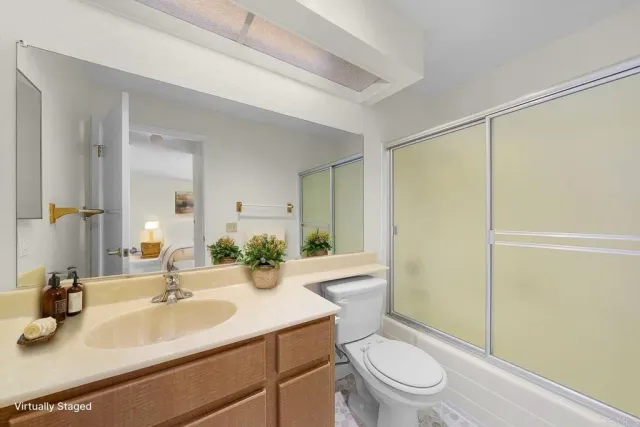 a bathroom with a sink a toilet a mirror and shower