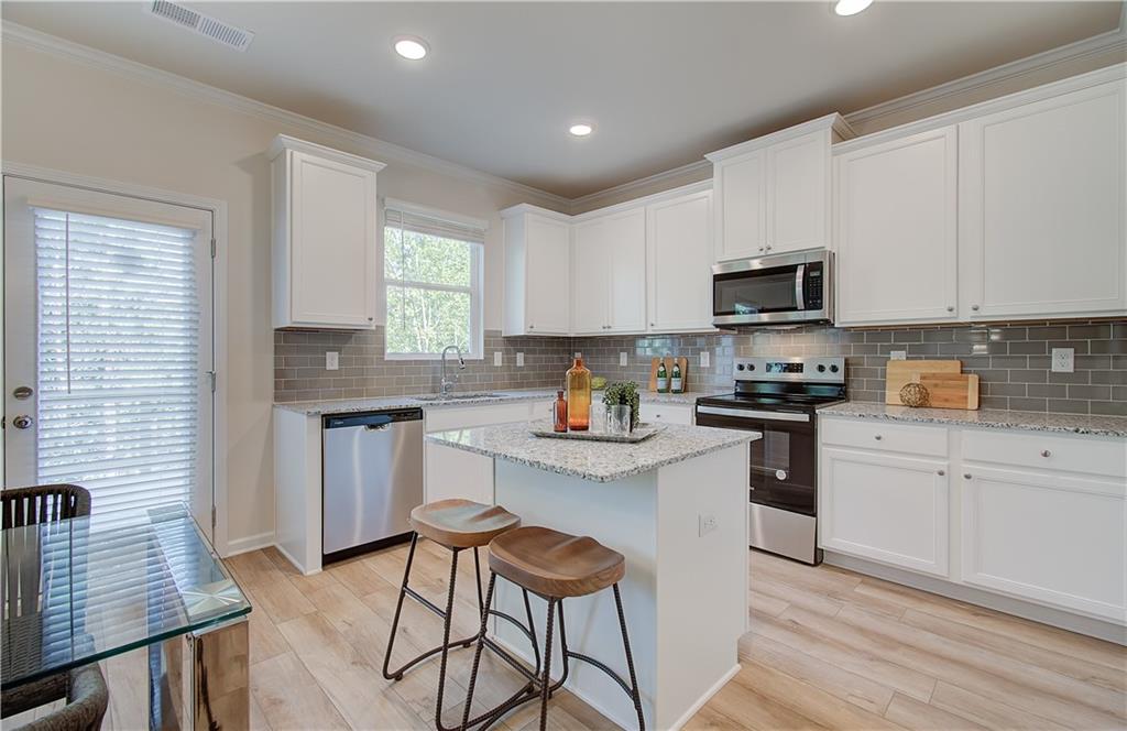 4581 Ajo Walk Atlanta, GA 30331 - Photo 12 of 19 a kitchen with granite countertop a stove sink microwave and refrigerator
