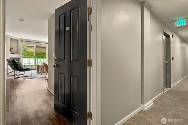 a view of a hallway with wooden floor and a livingroom
