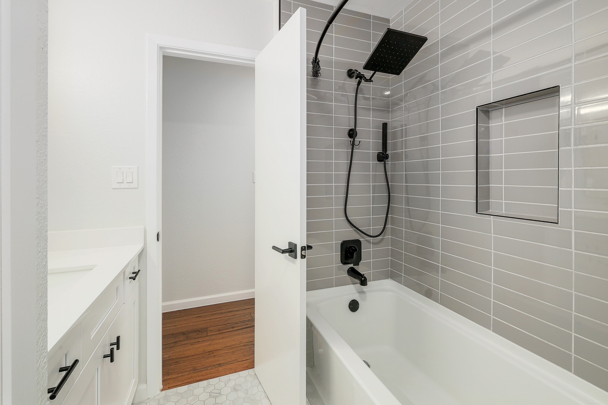 9614 Chukar Circle Austin, TX 78758 - Photo 21 of 26 The shower in the guest bathroom is fully renovated with a modern tub, subway tile backsplash, and designer hardware.