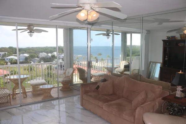 a living room with patio furniture and a floor to ceiling window