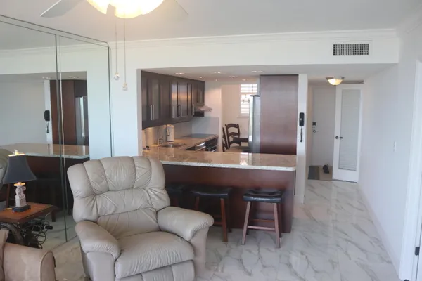 a living room with furniture kitchen island and stainless steel appliances