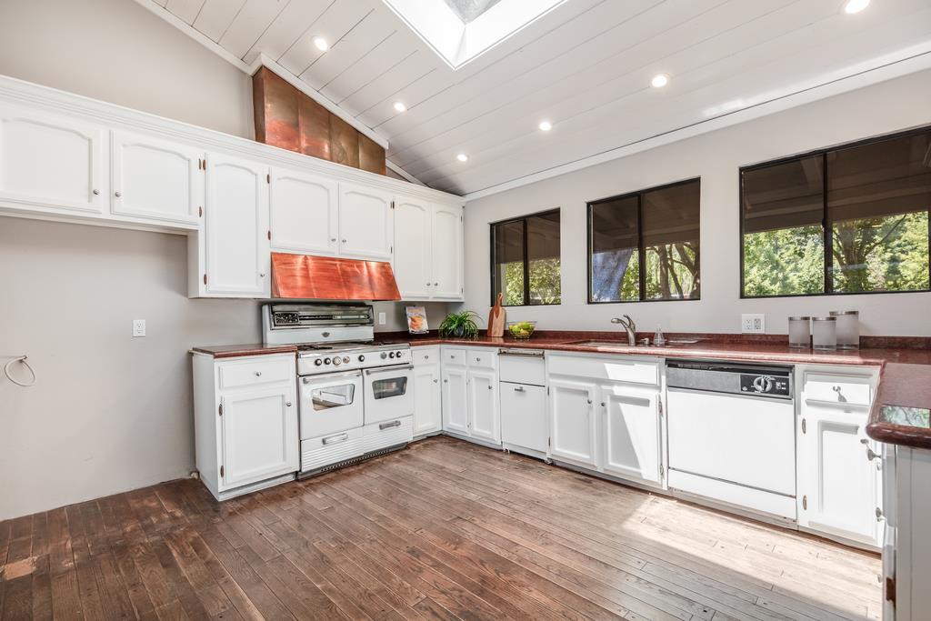 1975 Portola Road Woodside, CA 94062 - Photo 14 of 49 a kitchen with stainless steel appliances granite countertop a stove a sink and white cabinets