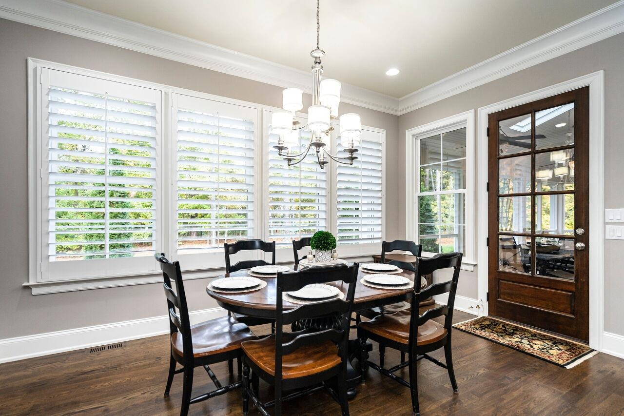 8401 Bournemouth Drive Raleigh, NC 27615 - Photo 16 of 41 Breakfast Room with 10' ceilings, two piece crown, wood/glass panel access door to screen porch, plantation shutters and hardwood floors. Cafe